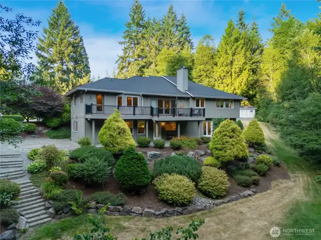 Custom-designed home in Maple Valley with manicured lawn, tiered landscaping, and a welcoming entryway—truly a standout property in 98038.