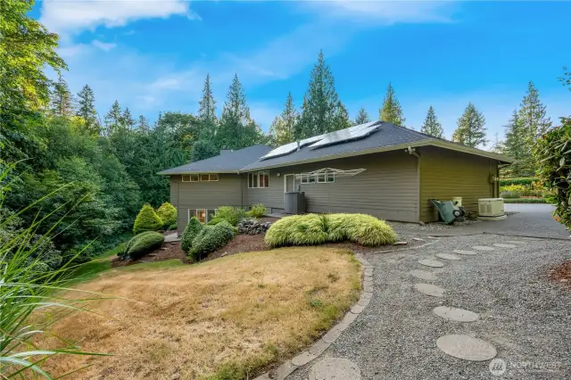 Side walkway with stone pathway and natural landscaping—adds privacy and convenience to this Maple Valley home.