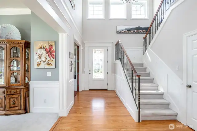 Front entry with natural hardwood floors and wide hall way filled with natural light. Open rail stairs with crown moulding, cased openings, shadow box detail and solid core doors throughout the home.
