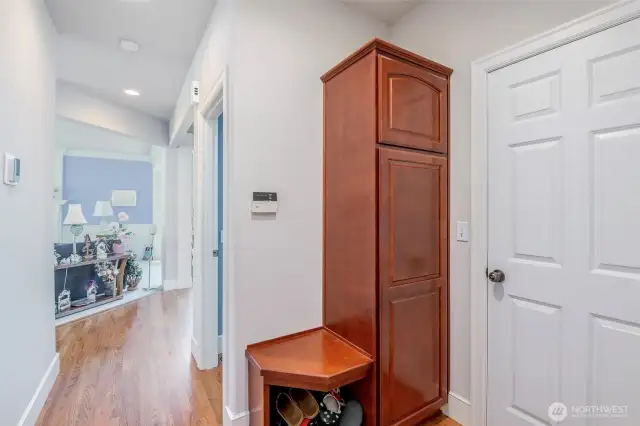 Small bench with shoe storage and tall cabinet for coats for additional storage.