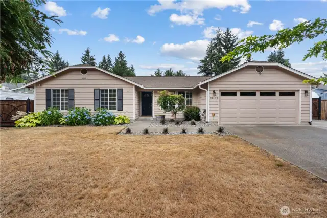 Front of the home featuring landscaping and two car garage.