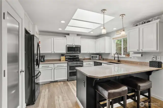 Kitchen showcasing the bar space, skylights and pantry.