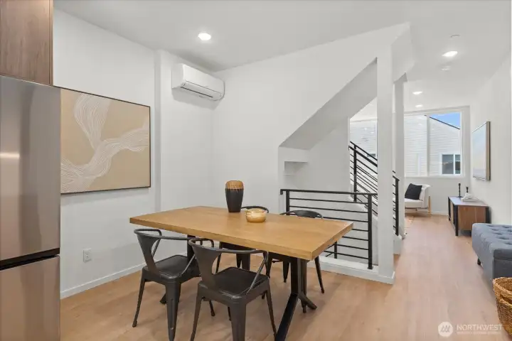 The open-concept layout connects the dining space with the living room, creating a bright and airy environment ideal for gatherings.