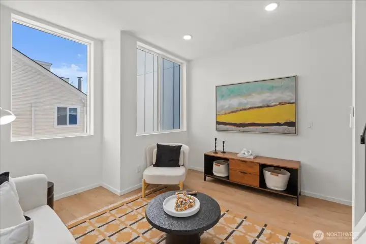 A modern living space framed by large windows and neutral tones provides the perfect setting for art and relaxation.
