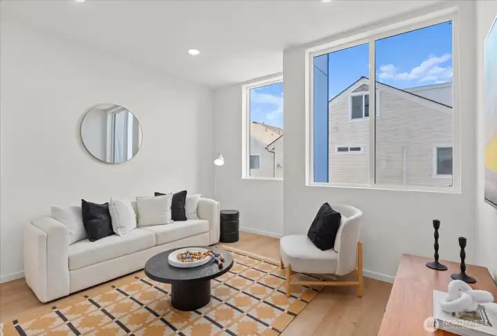 Expansive windows and a minimalist palette elevate this bright living room with stylish designer touches throughout.
