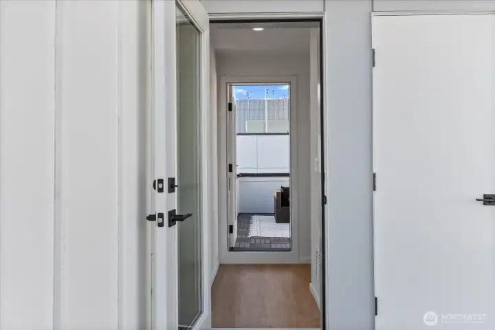 A sleek transition space leads directly to the private rooftop deck, creating seamless indoor-outdoor flow.