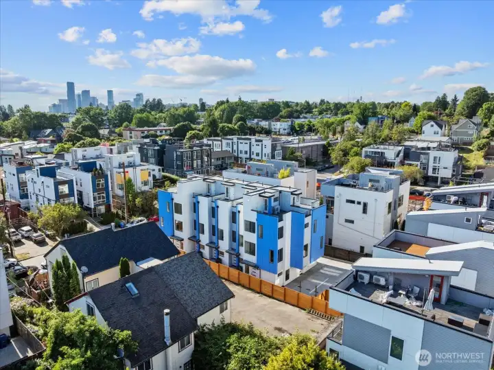 Modern townhomes stand out with bold blue accents and a central location surrounded by vibrant urban growth.