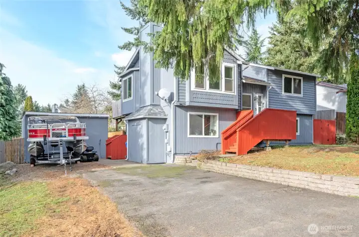 Another perspective of this refreshed home, featuring a detached shed behind the boat.