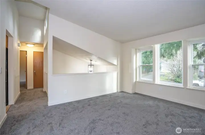 Living area featuring new carpet and a bright, updated windows.