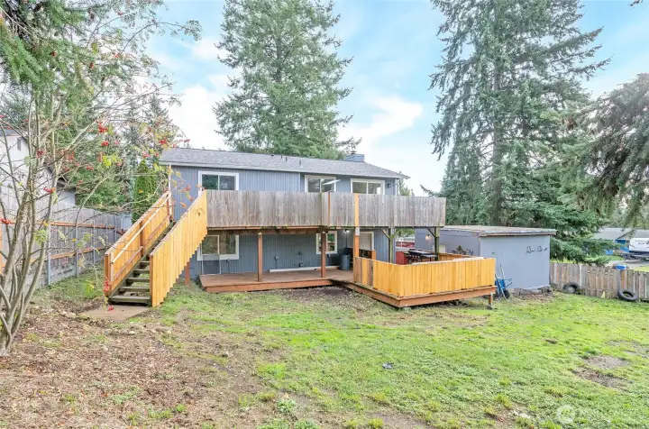 Rear exterior view highlighting the deck and a handy shed just to the right—perfect for storage or garden tools.
