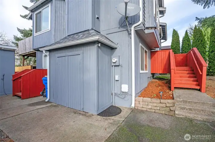 Driveway view of the home, featuring the MIL’s main exterior entrance on the left and an attached shed for added storage convenience.