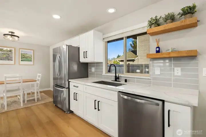 Chef's kitchen featuring SS appliances, quartz counters & oversized island.