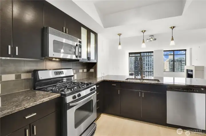 Rich espresso cabinetry paired with sleek stainless-steel appliances.