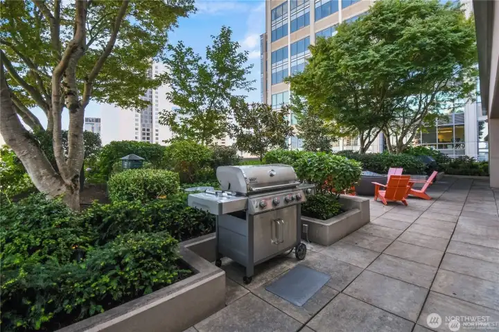 A rooftop terrace provides outdoor entertaining space with sweeping views. The Rooftop terrace of the Cosmopolitan in Seattle, offering an impressive vantage point of the city and waterfront.