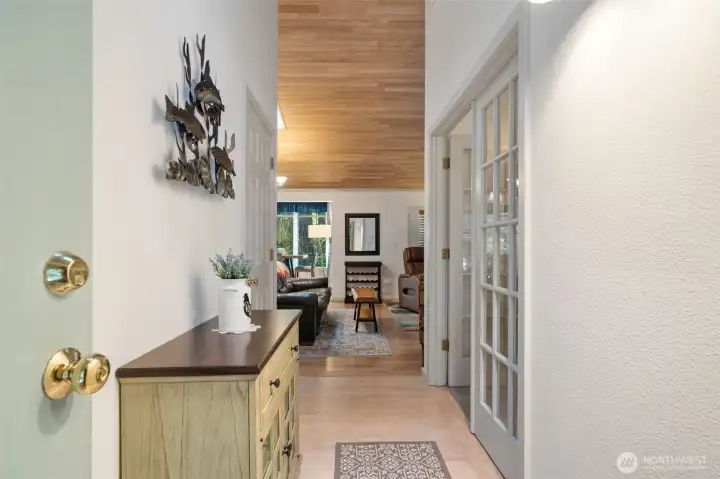 Entry hallway to living room.  Bedroom with French doors on right side.