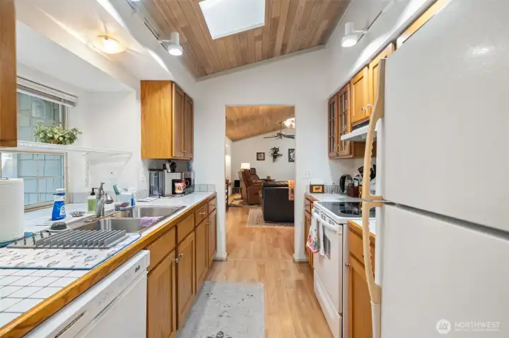 Galley kitchen toward living room w/window to deck.