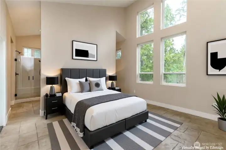 soaring ceiling in primary suite compliments ample windows for bright atmosphere.