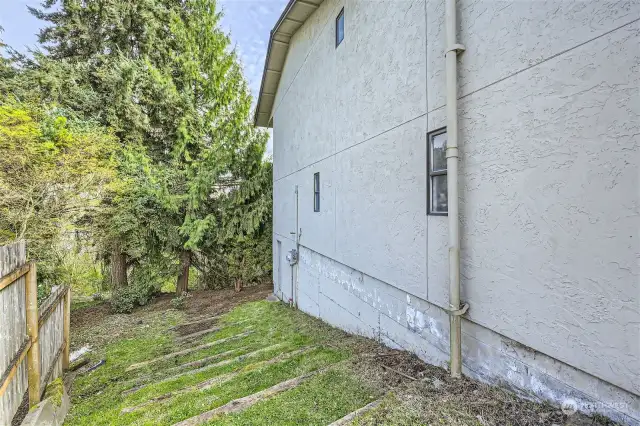 Grassy steps leading from front of home down to main backyard.