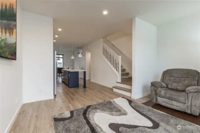 The family room as it looks into the kitchen area, and the stairs leading to the bedrooms