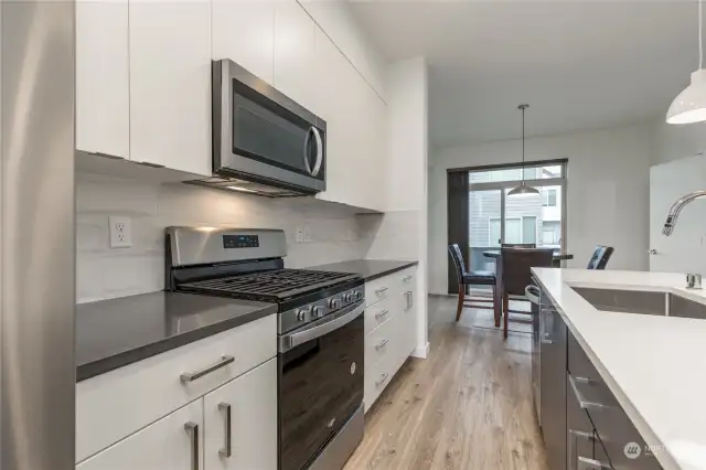 A view of the counters, cabinets and dining room.  The cabinets are soft-close. and there is a stainless steel undermount sink