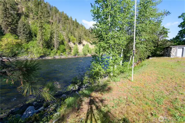View of the river from the building site. Historic stone structure has power & could be a studio, sauna, or storage shed.