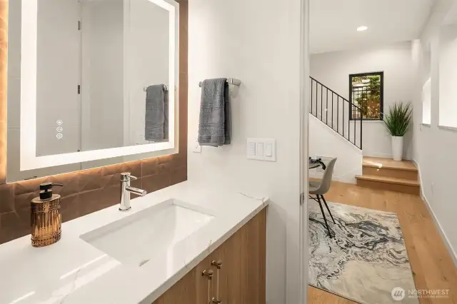 Powder bath conveniently located on the mai floor with back light mirror and wall mount vanity