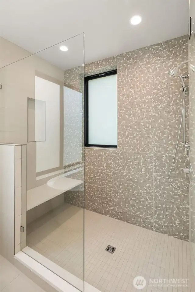 The primary suite includes a spacious walk-in shower. Tile color will vary