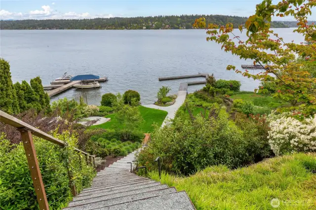 Architectural steel and crushed gravel steps down to the lower yard and dock. Lush native landscaping