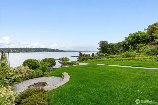 Large lawn area with stone fire pit.
