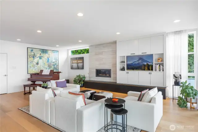 Living room with custom built-ins and fireplace with stone facade.