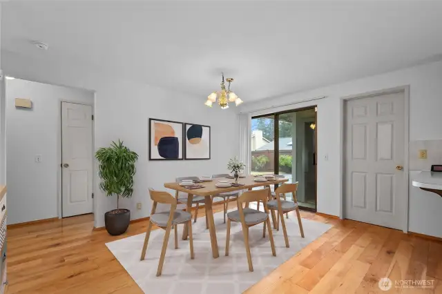 Virtually staged dining space with door to fenced backyard