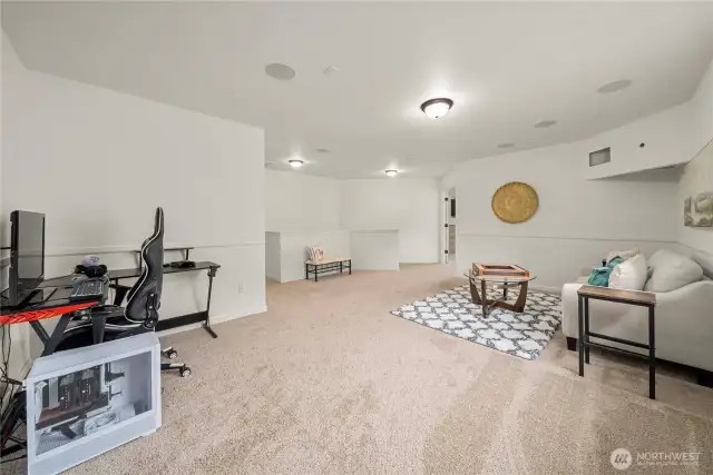 Third living space as seen from the laundry room. Straight ahead is the incredible primary suite. On the left is the hallway leading to three additional bedrooms!