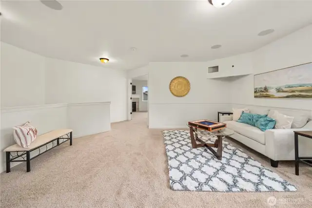 Third living space as seen from the laundry room. Straight ahead is the incredible primary suite. Out of sight on the left is the hallway leading to three additional bedrooms!