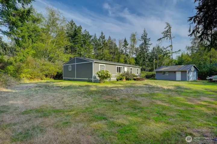 Angled view from front yard looking toward house and shop/garage