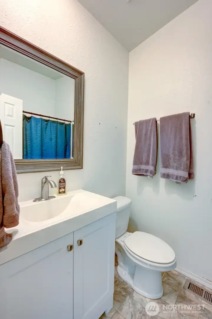 Full bathroom with updated vanity, mirror, and shower/tub combo.