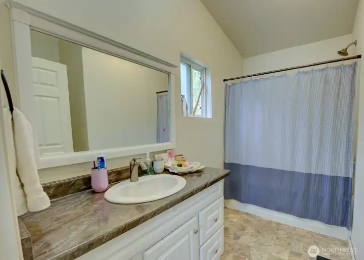 En-Suite full bathroom with oversized vanity, large mirror, window and tub/shower combo