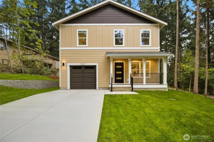This is a custom-designed, contemporary home featuring a prominent covered front porch, offering a welcoming and stylish entry.