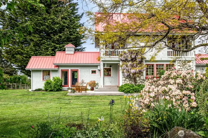 Main house seen from spring blooms within the fenced flower/vegetable garden and vineyard.