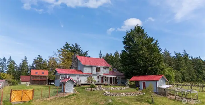 West side of the house with chicken coop/potting shed, with the shop/garage and apartment to the left and the guesthouse in the far left background