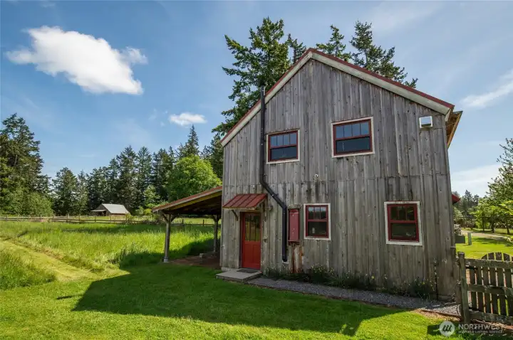Shop/garage side entrance with hay barn in the left background, with dry winter pasture in between