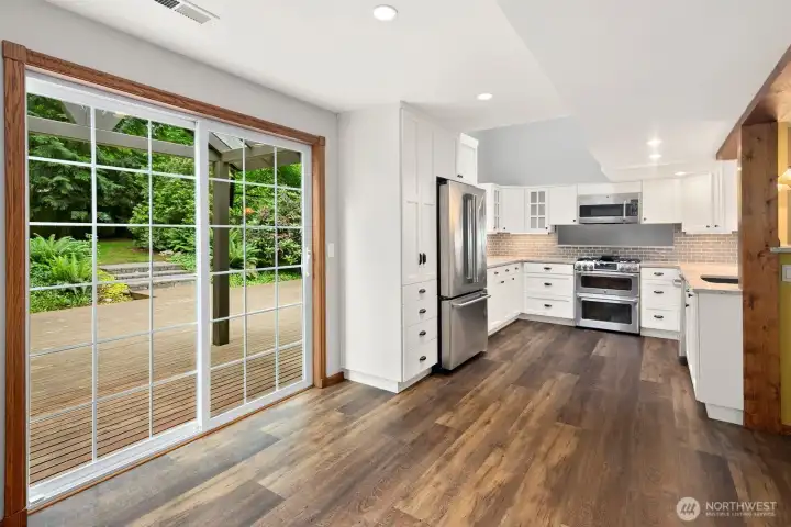 Glass slider from the kitchen dining area leading to the large wooden deck