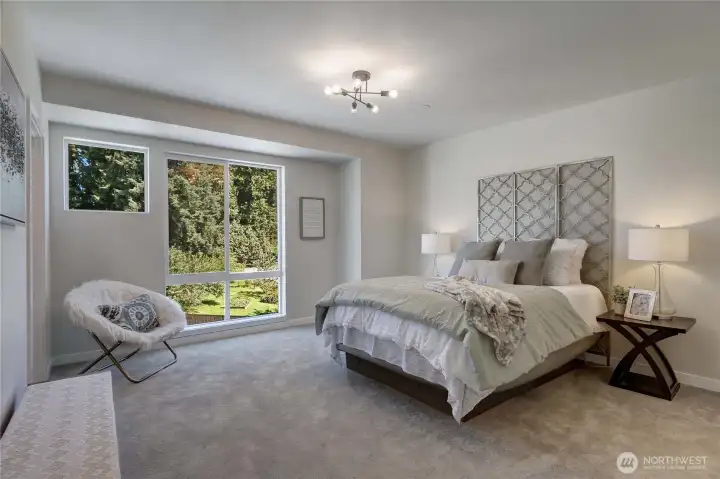 The upper level Primary bedroom has a floor-to-ceiling window that floods the room with light, as well as a walk-in closet and separate bath.