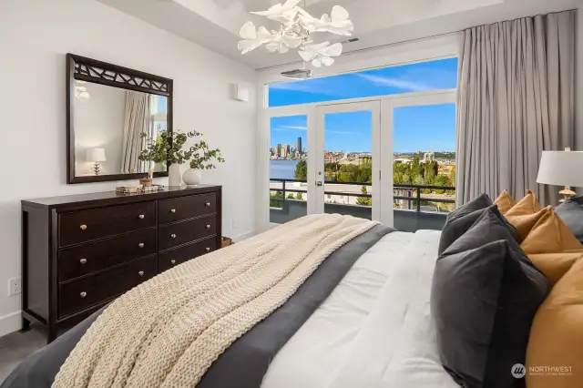 Primary bedroom features high ceilings, designer lighting and expansive balcony with amazing views!