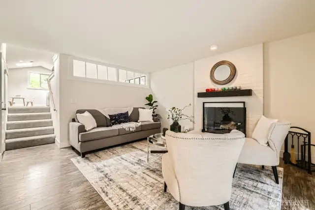 A cozy fireplace in the family room invites relaxation. Steps up lead to the bonus room.