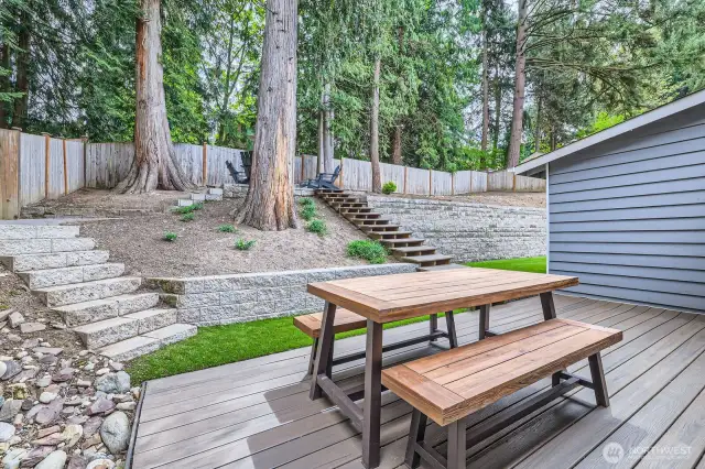 Relax or entertain on the deck overlooking a tranquil treed setting. Stairs up lead to an upper level.