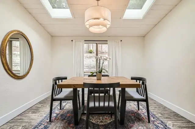 The formal dining room is infused with natural light from a window overlooking the backyard and skylights.