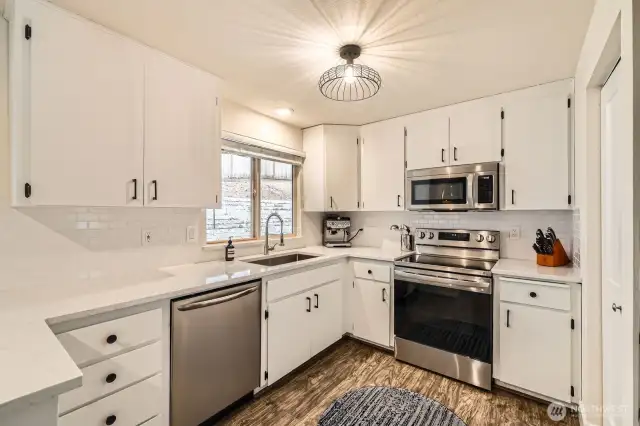 The remodeled kitchen impresses with stainless steel appliances, a new oven, quartz countertops and backsplash.