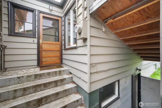 A view of the back of the home with basement door visible in the lower right.