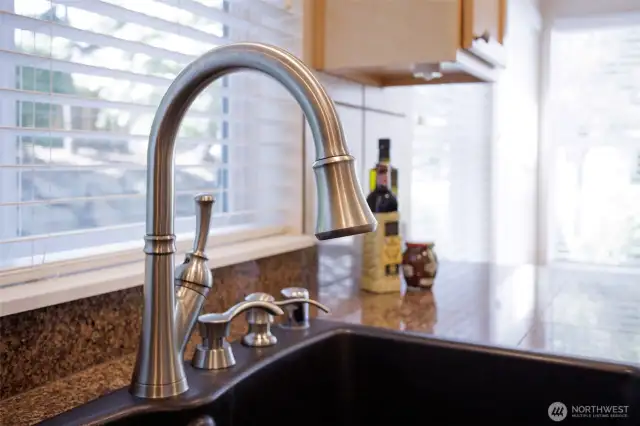 Granite composite double sink and multiple soap dispensers.