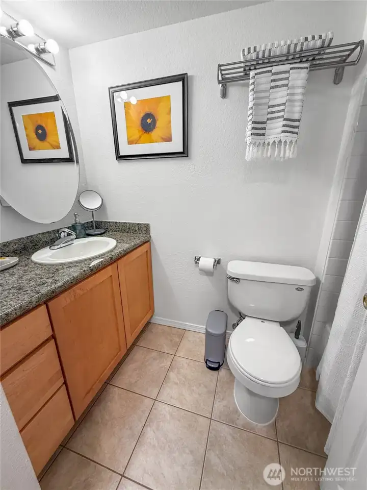 The bathroom is right next to the entry, across from the kitchen.